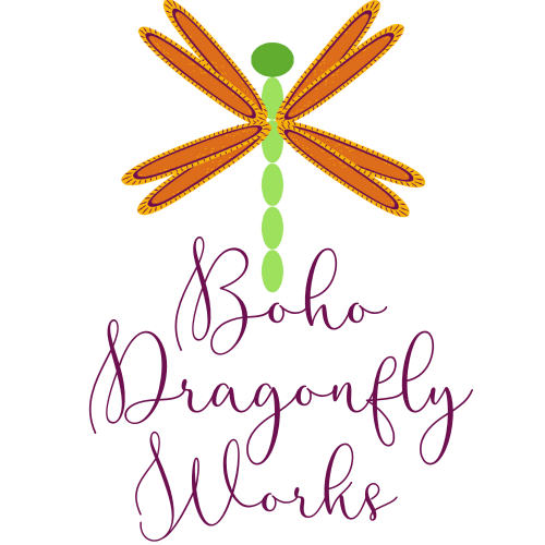 Cartoon dragonfly logo with four orange wings and a green body. The Business name Boho Dragonfly Works.